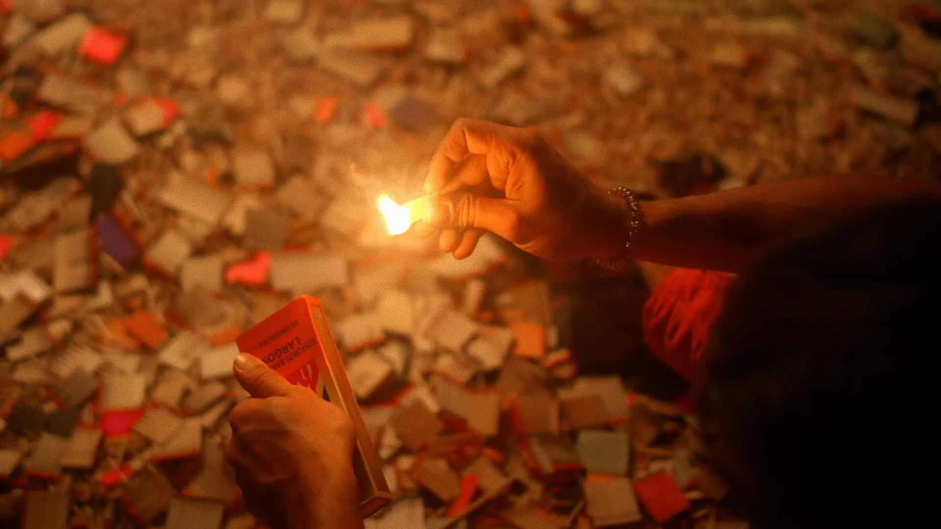 A person holding a lit candle in their hand